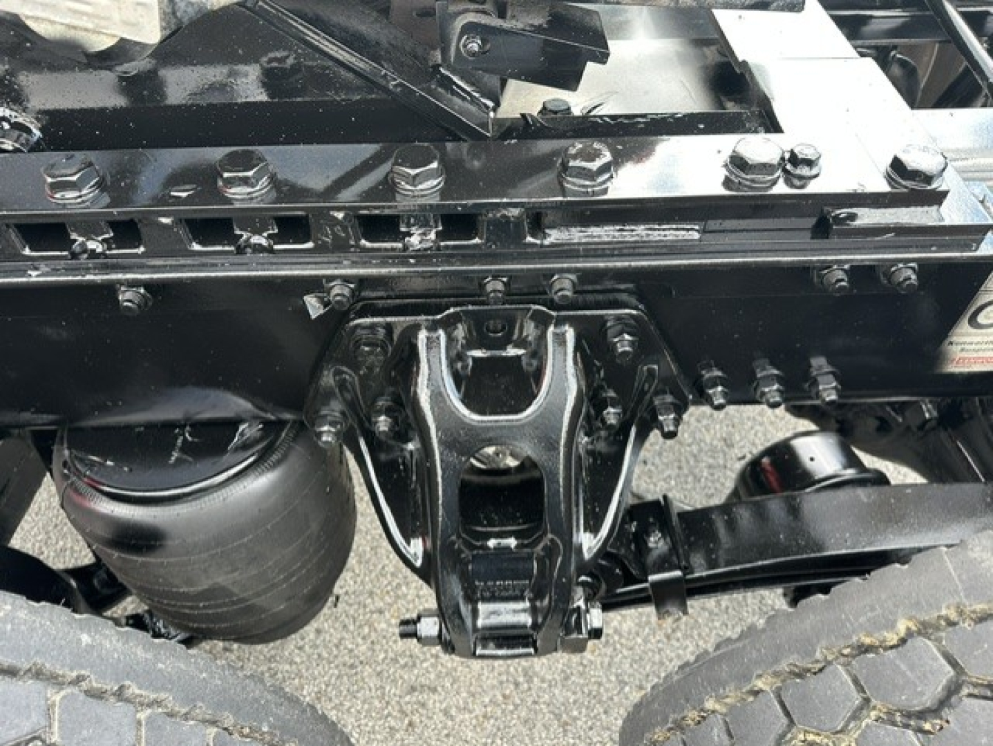 Kenworth T880 rear chassis and fifth wheel hitch showing frame rails and air lines.
