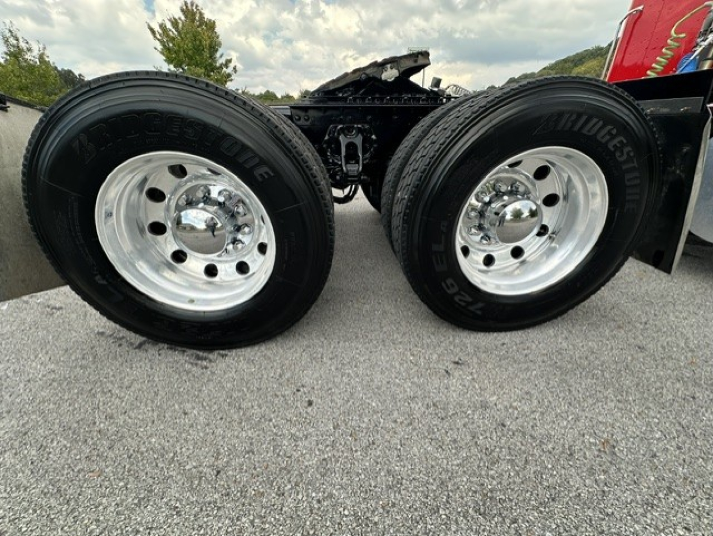 Kenworth truck rear dual wheels showing chrome rims and Bridgestone tires in a sleeper-conventional configuration.