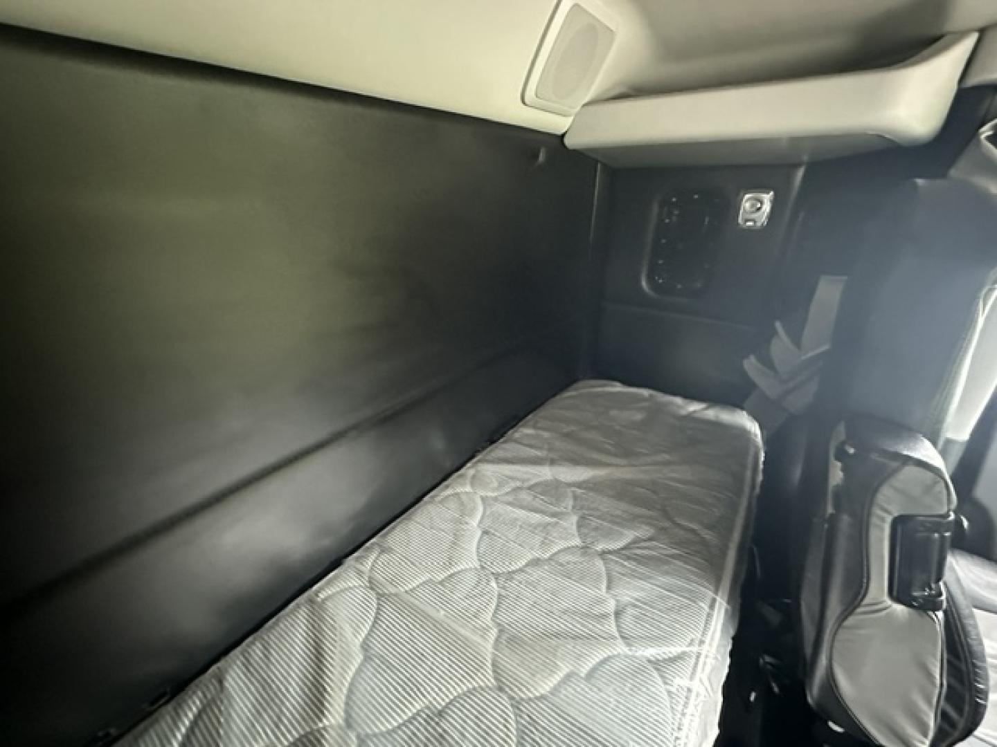 Kenworth T880 sleeper cab interior showing a narrow bunk bed with mattress and surrounding panels.