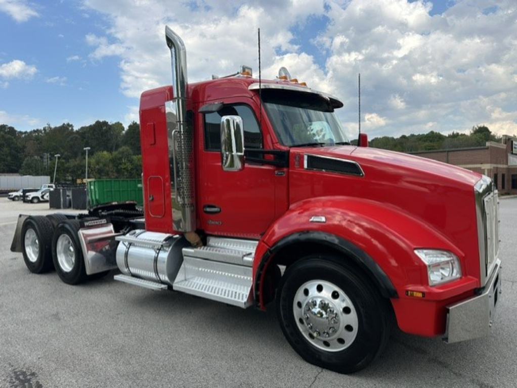 Kenworth T880 tractor-trailer in red, side view, showing sleeper cab, chrome exhaust stacks, aluminum steps, and front bumper.