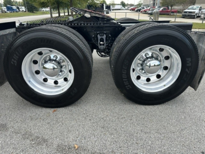 Dual rear tractor tires on a Kenworth truck chassis with polished steel rims and dual wheels, trailer hitch area visible.