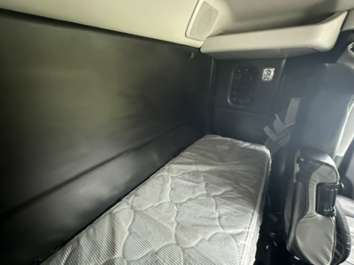 Kenworth T880 sleeper cab interior showing a narrow bunk bed with mattress and surrounding panels.
