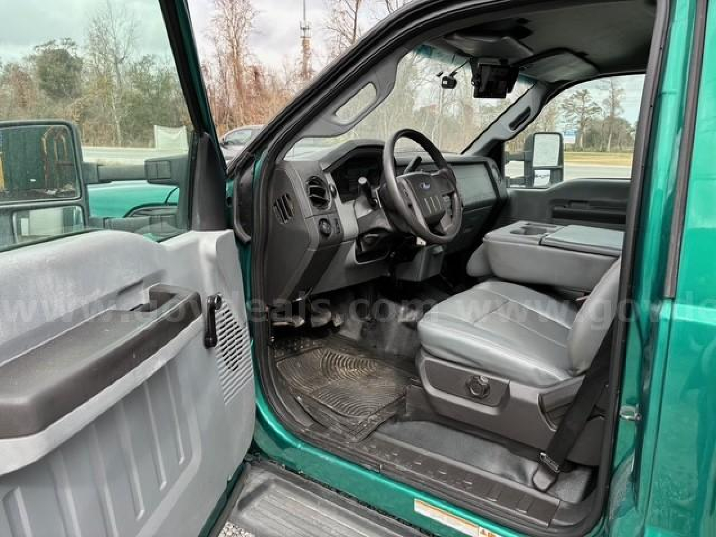 Ford F-550 cab interior showing driver seat and dashboard view from open door.