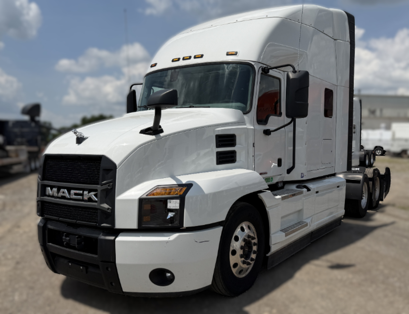 Truck side/front view showing white Mack ANTHEM tractor with black grille and headlights, cab exterior details visible, no visible text other than brand on grille