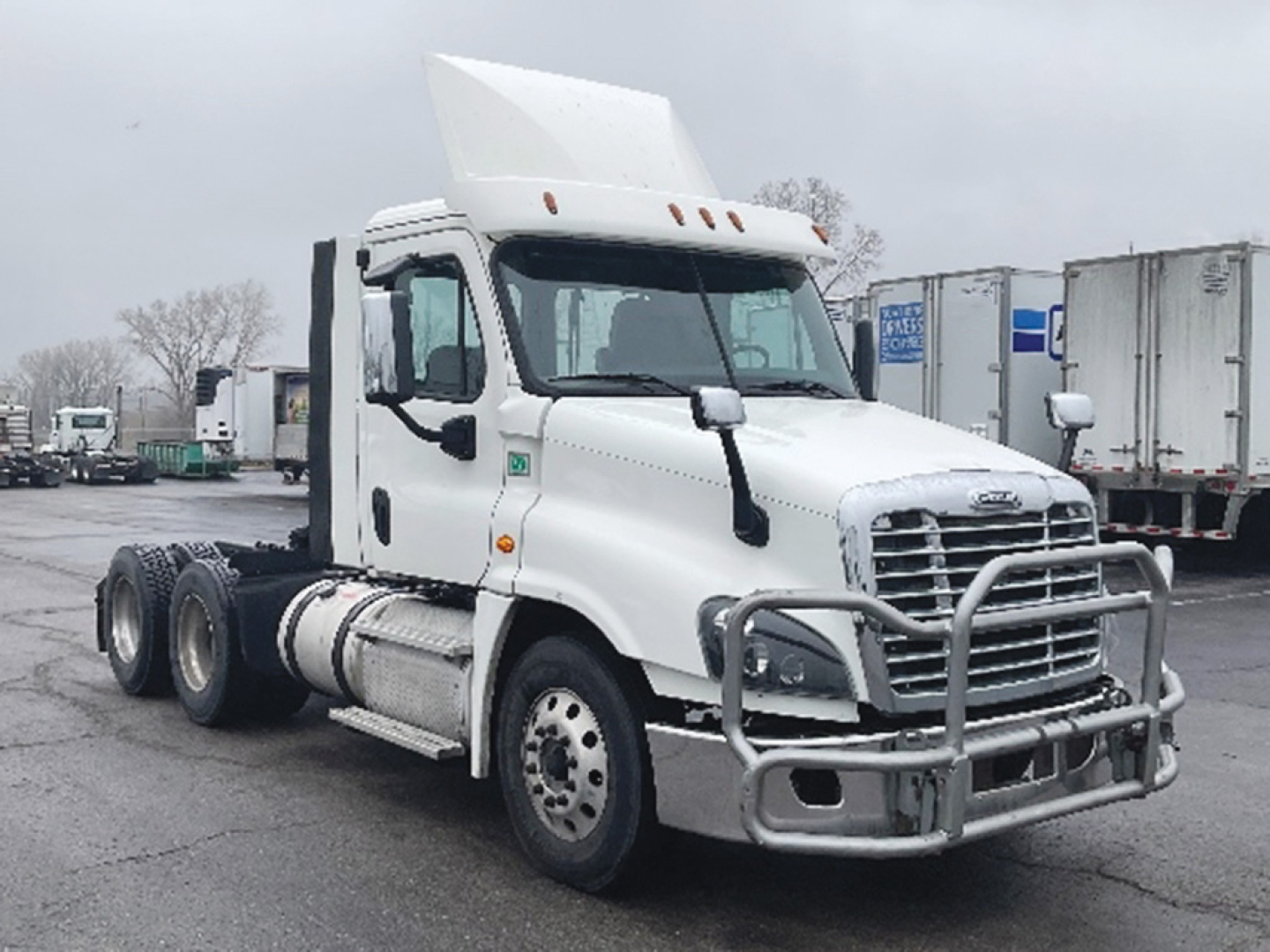 Truck cab showing Freightliner Cascadia125 daycab with chrome grille guard, white exterior, dual rear axles, and sleeperless cabin.