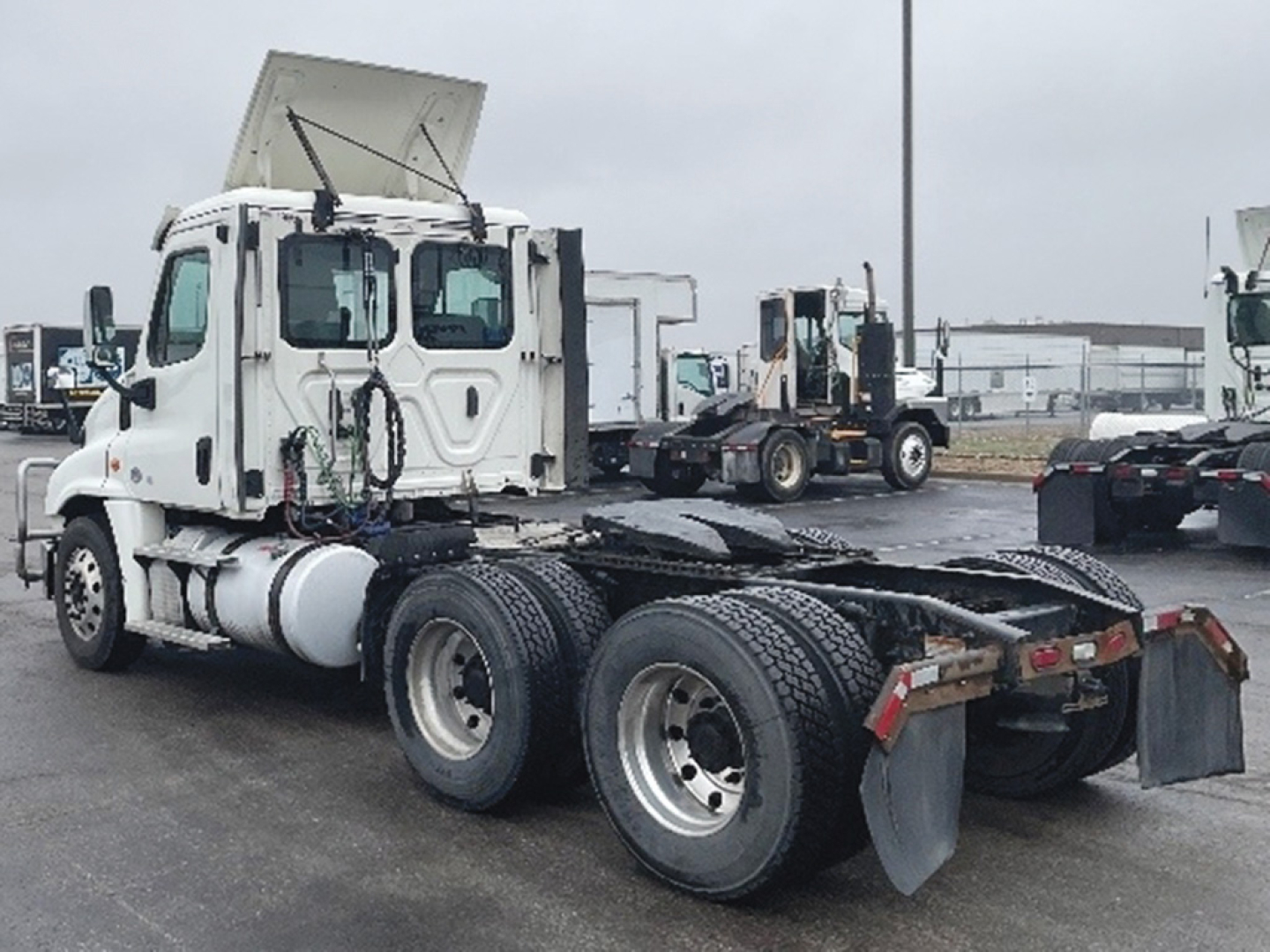 Freightliner Cascadia125 tractor with daycab configuration from rear-left view, showing chassis and fifth wheel area.
