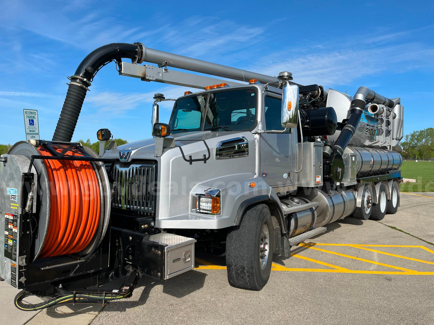 Western Star Vactor 2100PD sewer jetting truck, side view showing large orange hose reel, front grille, multiple storage compartments, and vacuum/jetting equipment mounted on a heavy-duty chassis.