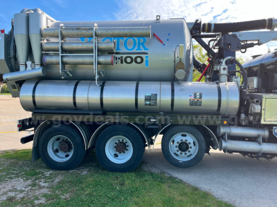 Truck-mounted Vactor 2100i sewer jetting system on a three-axle trailer showing large stainless tank with VACTOR 100i branding and hoses.