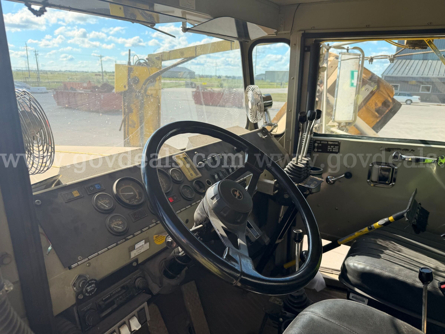 Cab interior of 1993 Oshkosh PA-2523-3 truck showing steering wheel, dashboard gauges, gear levers, and auxiliary controls.