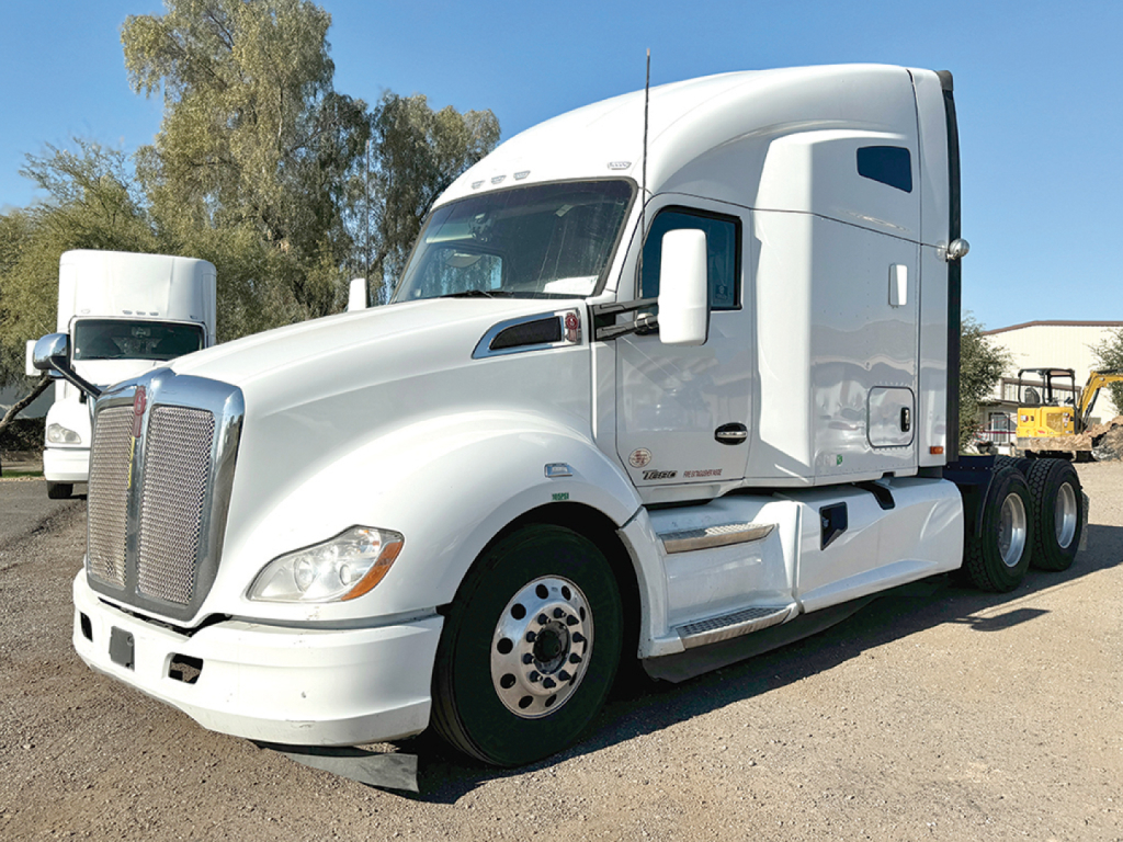 2018 Kenworth T-680 tractor cab in white, side view, with large grille and sleeper cabin.