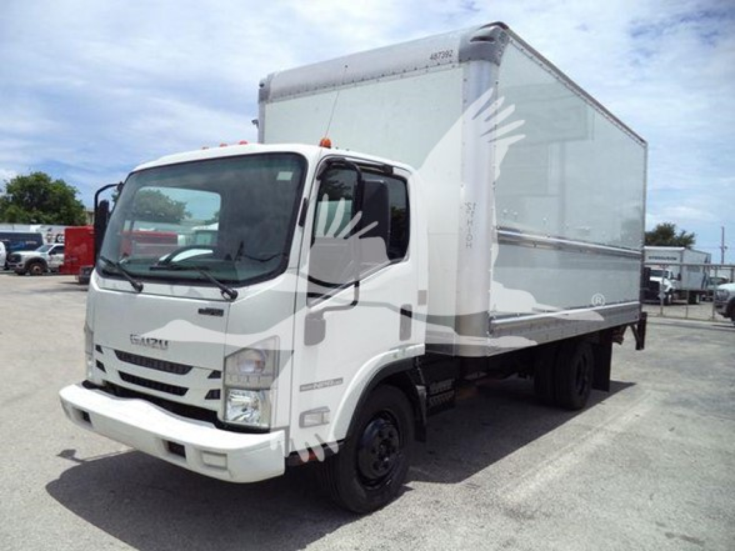 Isuzu NPR HD box truck in service showing cab and box.