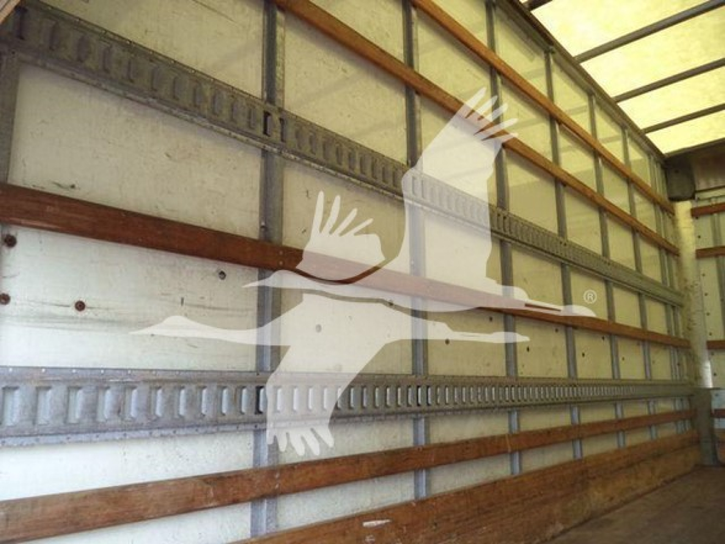 Isuzu NPR-HD box truck cargo area interior with metal walls and wooden rails.