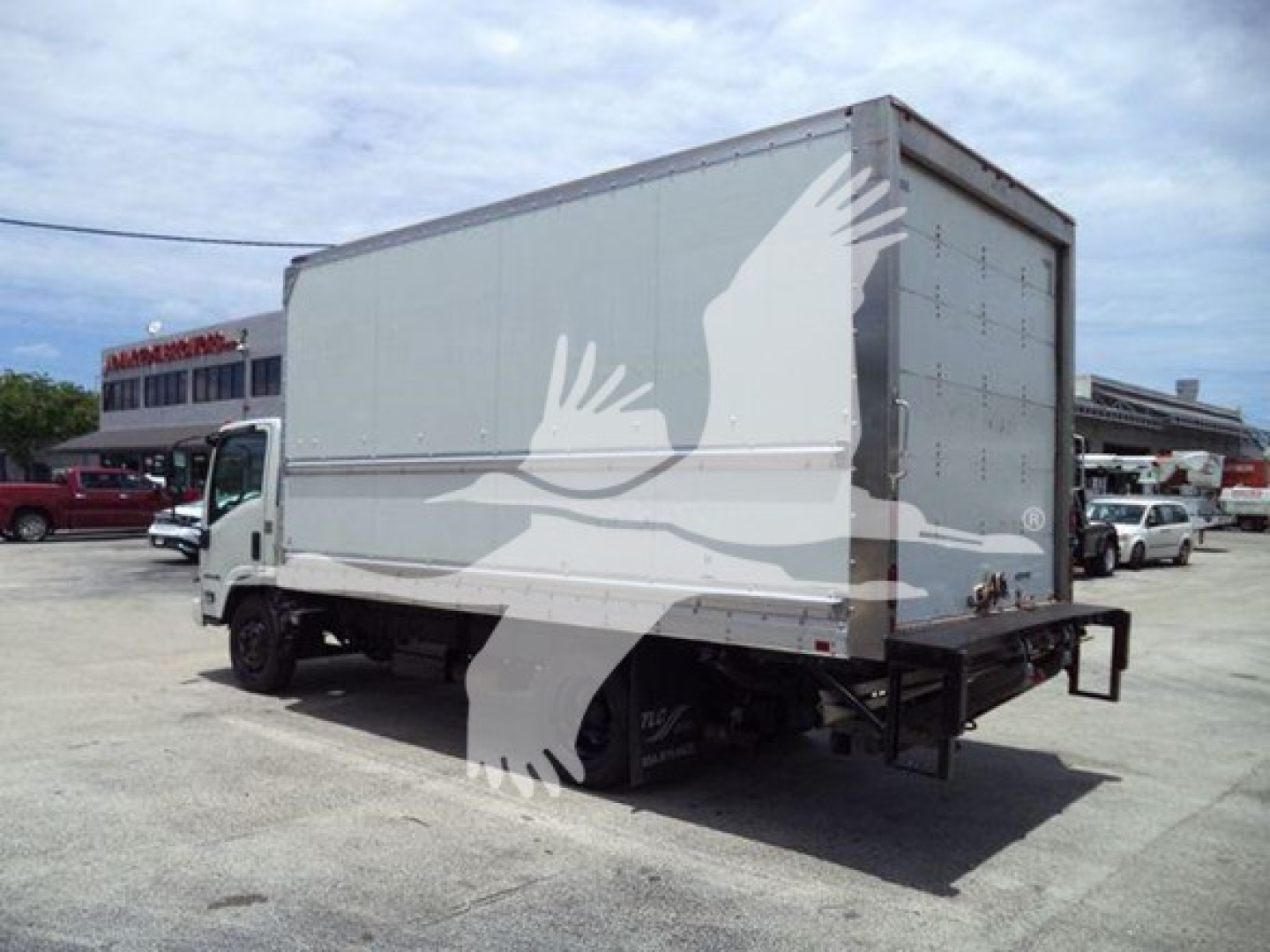 Isuzu NPR-HD box truck rear-side view showing cargo box and rear lift.