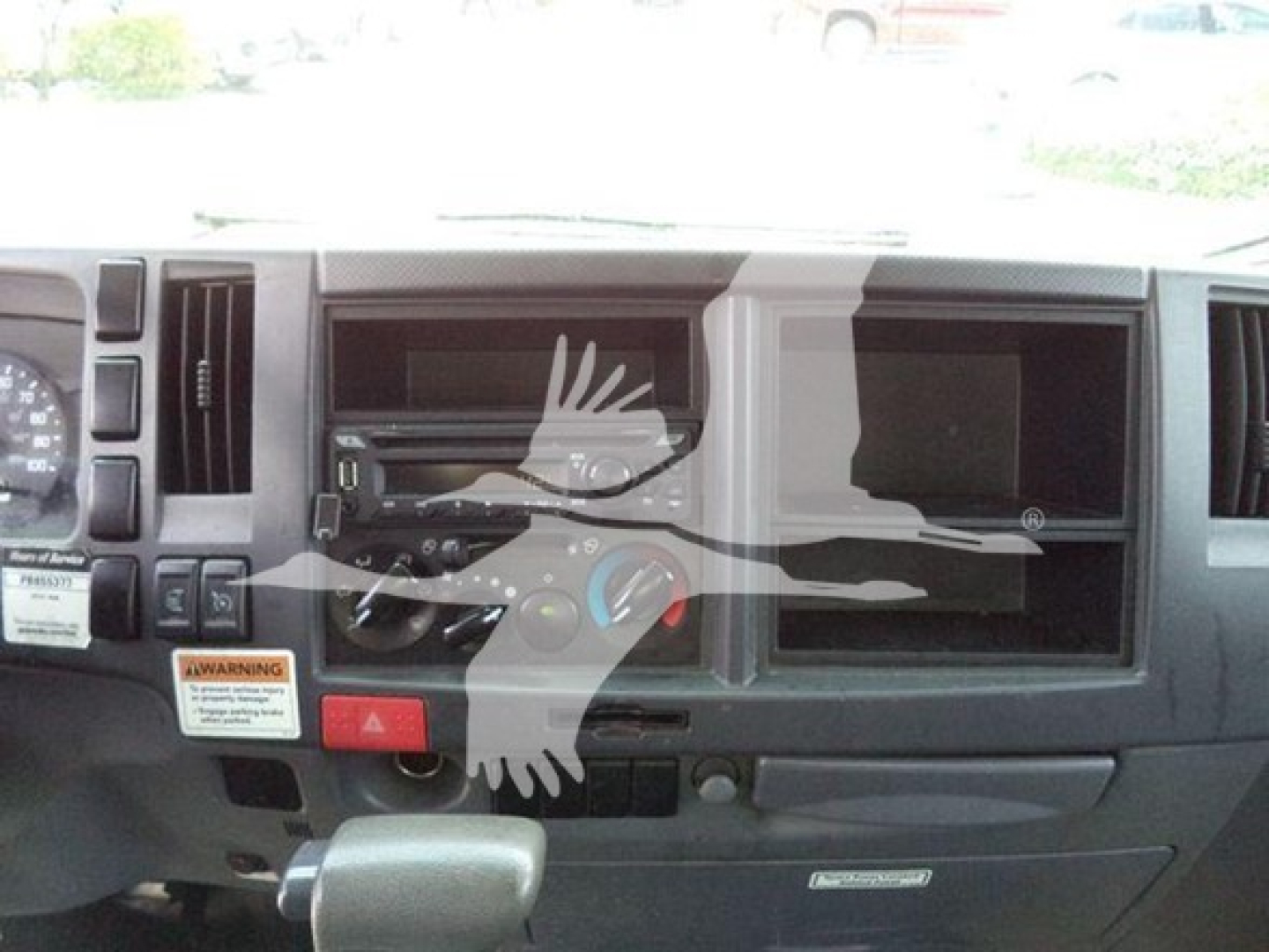 Isuzu NPR HD truck dashboard/center console with air vents, control knobs, and empty radio slot.