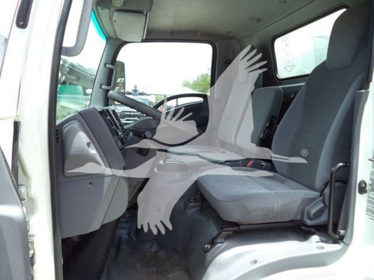 Isuzu NPR HD truck interior showing driver seat and passenger seat with dashboard and steering wheel.