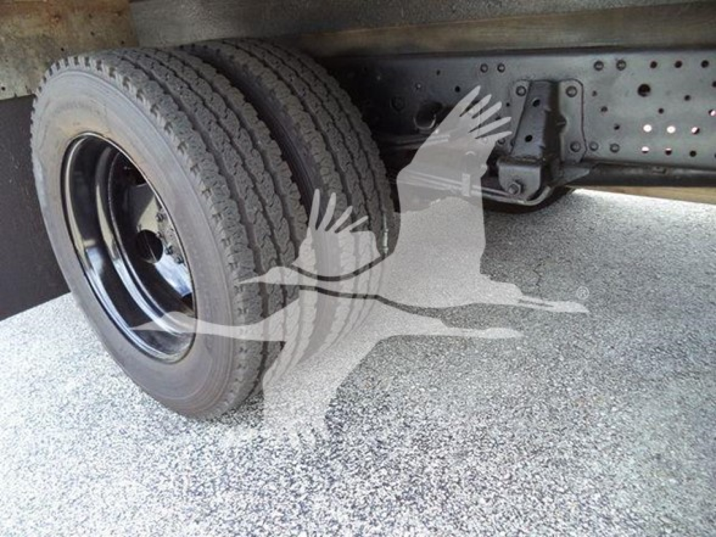 Isuzu NPR HD truck chassis with dual rear wheels and undercarriage components visible.