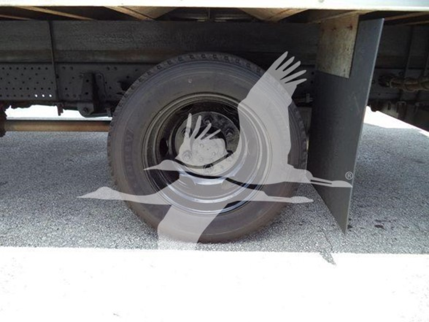 Isuzu NPR HD truck undercarriage with wheel and mud flap; no clear text visible on components.