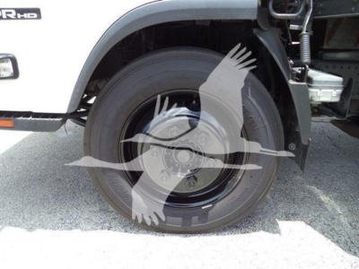 Isuzu NPR HD truck front wheel and fender showing wheel and suspension components.