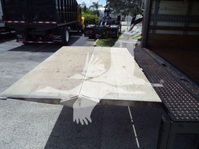 Isuzu NPR HD box truck rear view showing a flatbed or loading ramp attached to a side utility platform.