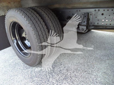 Isuzu NPR HD truck chassis with dual rear wheels and undercarriage components visible.