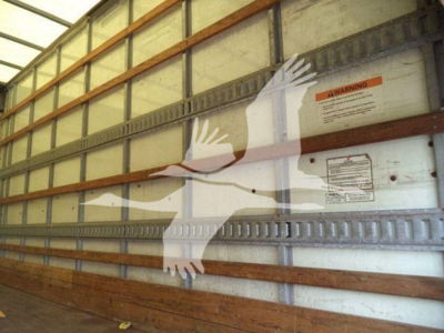 Isuzu NPR HD truck interior wall with warning label and horizontal support rails visible.