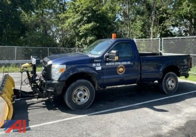 2011 Ford F350 Super Duty pickup with plow and lift gate, blue crew cab 4x4 truck in parking lot.