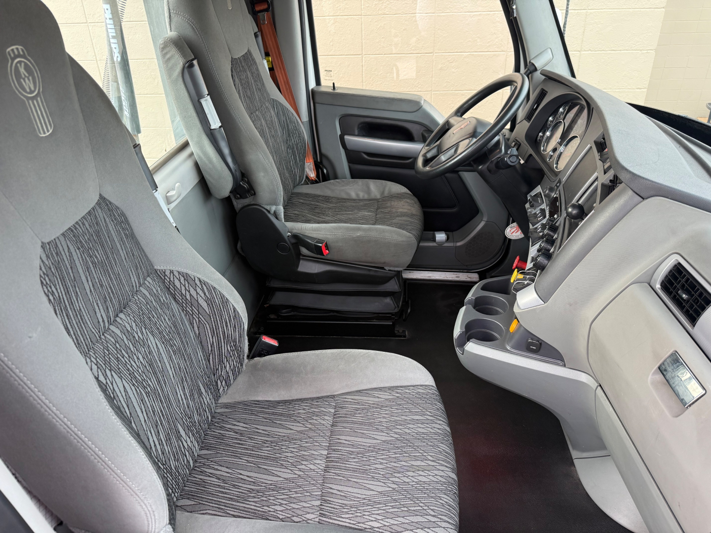 Kenworth T680 truck interior showing front seats and dashboard.