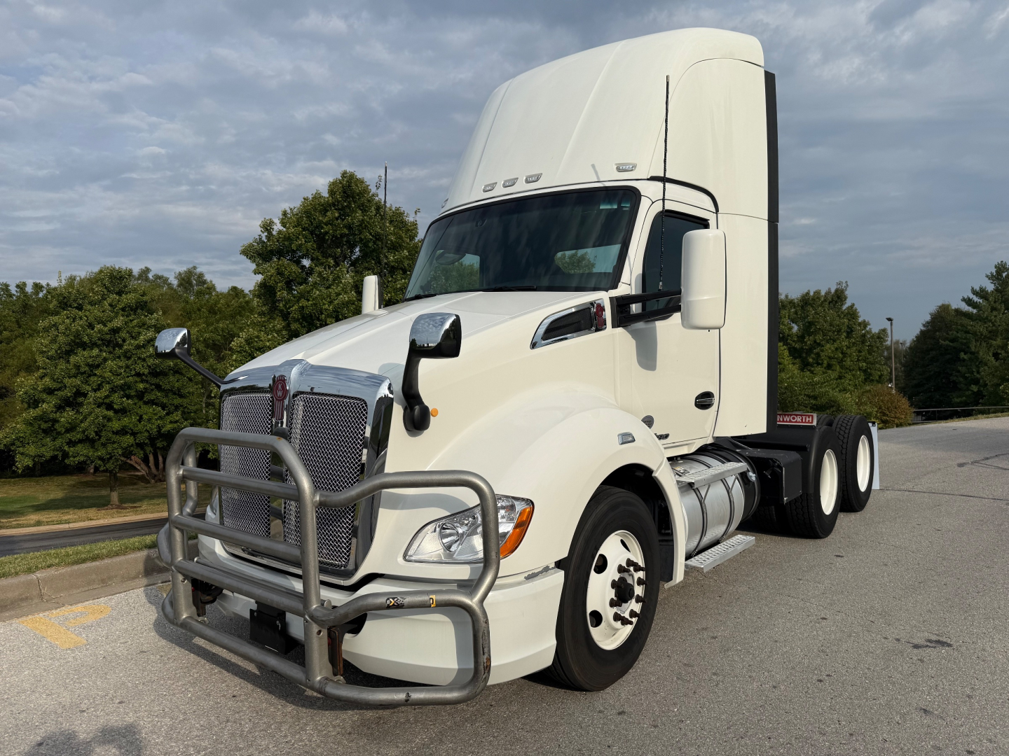 Kenworth T680 tractor in white with front grille guard, large sleeper cab, dual rear axles, and side fuel tanks.