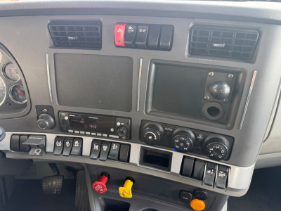 Kenworth T680 dashboard panel showing various switches and gauges, cab controls, and climate dials.