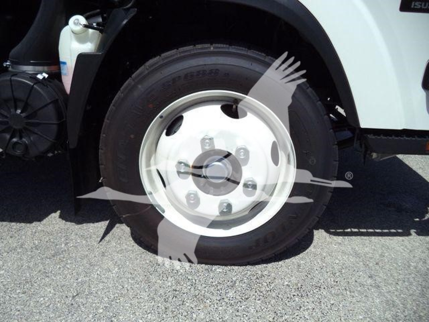 Isuzu NPRR rolloff truck wheel and front fender showing silver steel wheel and tire tread