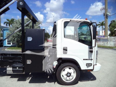 Isuzu NPRR roll-off truck cab side showing wheel and toolbox, with black metal hydraulic body behind cab, white cab color.