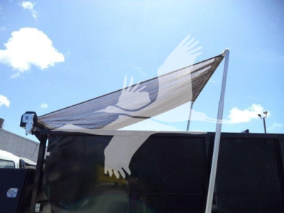 Isuzu NPRR box truck in a lot, side view with a raised tarp mechanism and a flatbed/roll-off setup. No visible model badges in the image.