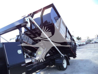 Isuzu NPRR roll-off truck bed in raised position showing hydraulic tilt mechanism and side controls.