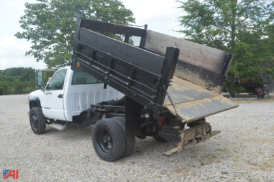 Dump truck bed of a 2002 GMC Sierra 3500 dump truck in service position with raised bed and hydraulic mechanism visible.