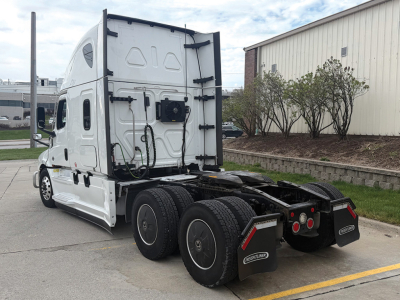 Freightliner Cascadia126 tractor truck rear view showing sleeper cab and dual rear axles with mud flaps and frame, white exterior.
