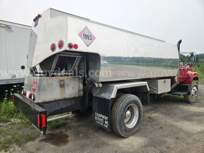 Tank truck rear view showing tanker shell with hazard diamond 1993 and rear equipment panel; GMC C7500 chassis with dual rear wheels.