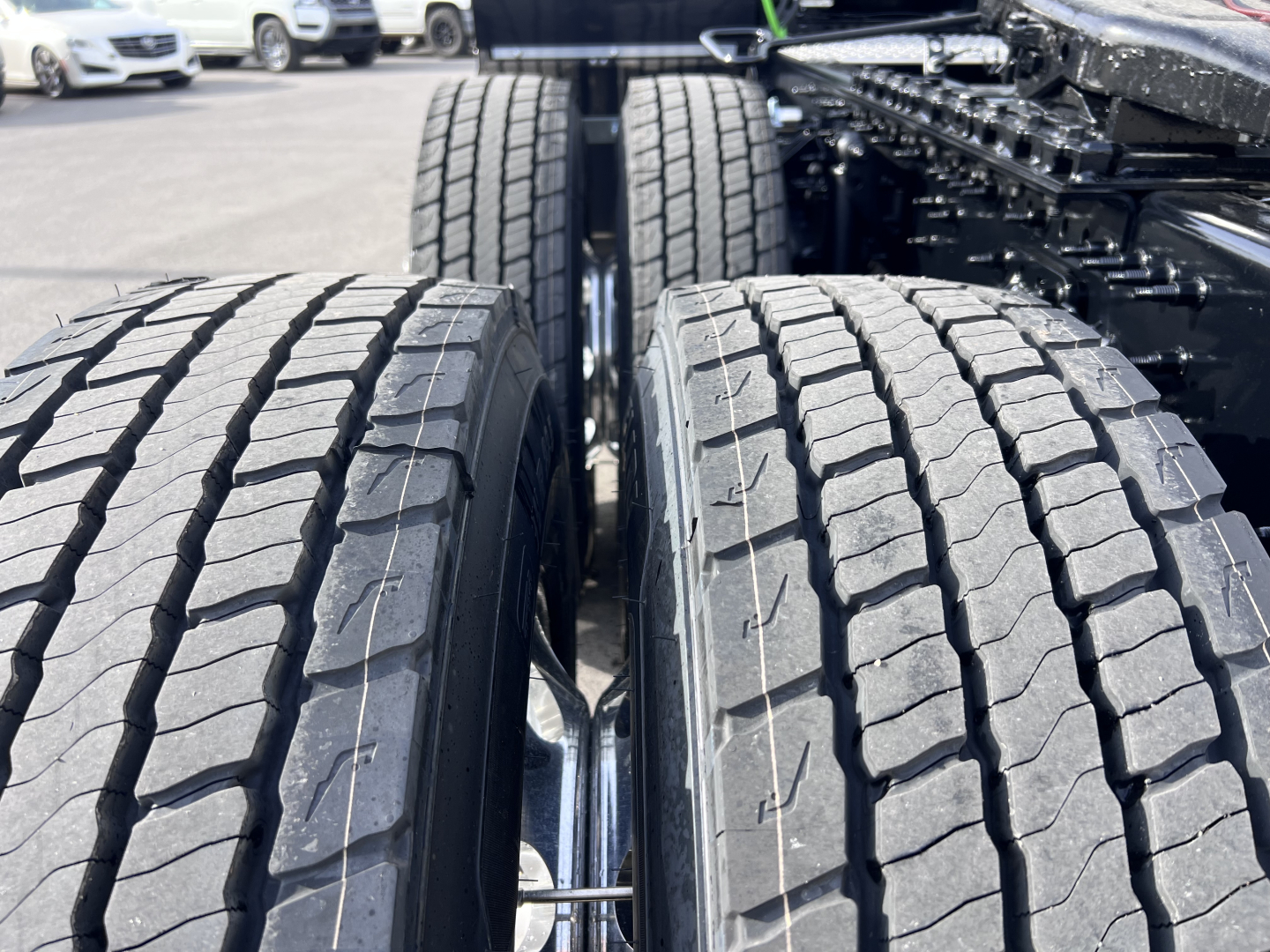Volvo VNL64T840 truck drivetrain focusing on dual rear axles with treaded tires and suspension components visible.