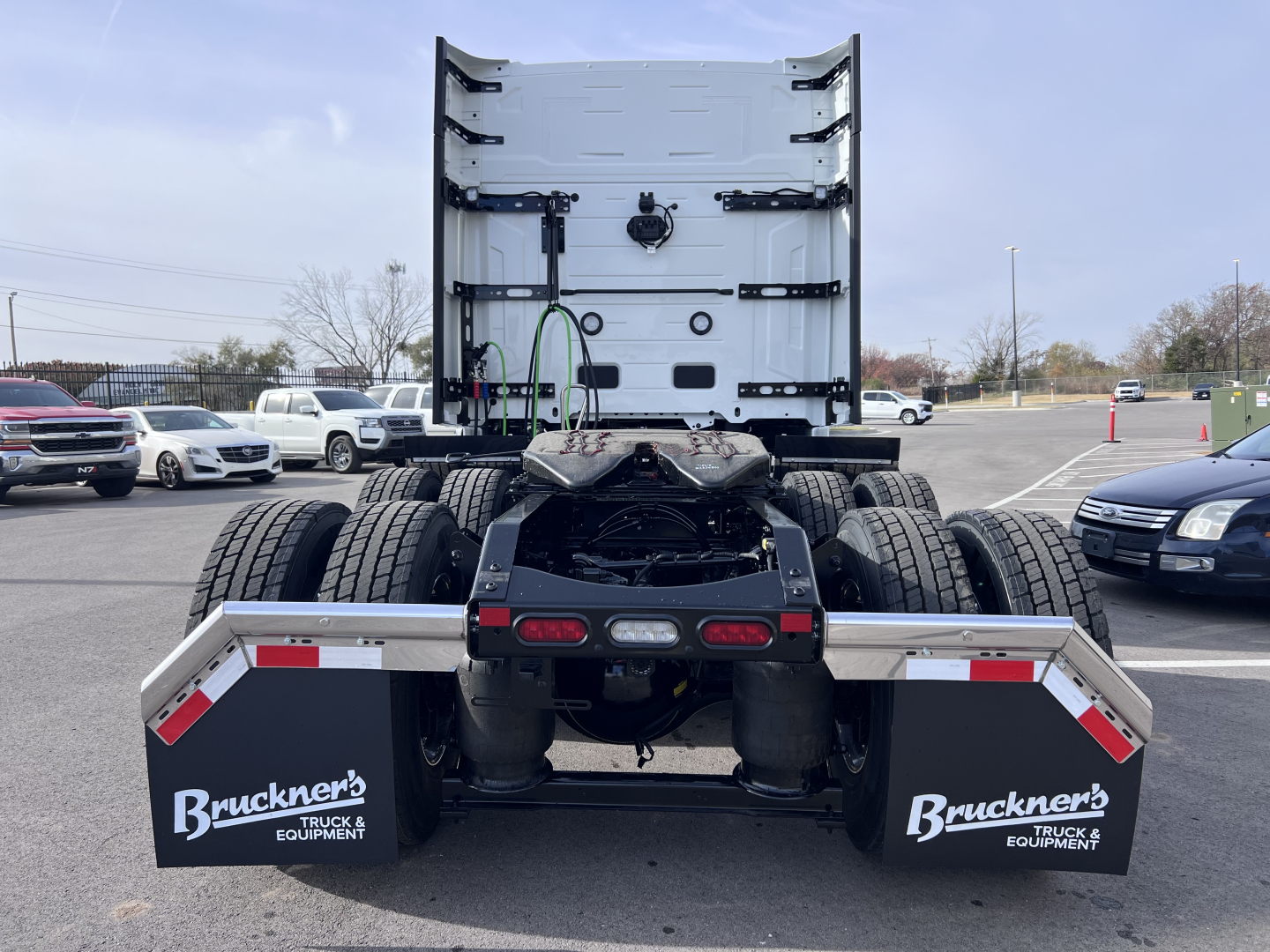Rear view of a new Volvo VNL64T840 truck tractor chassis showing fifth wheel, dual rear axles, brake lights, and mud flaps with Brunker’s Truck & Equipment logo.
