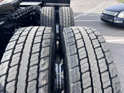 Front dual rear wheels of a Volvo VNL truck showing large tires with tread, part of the chassis and frames visible.