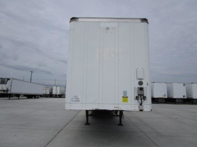 Trailer rear view of a 2014 Stoughton van trailer with landing gear raised, white exterior, and side door hardware visible.