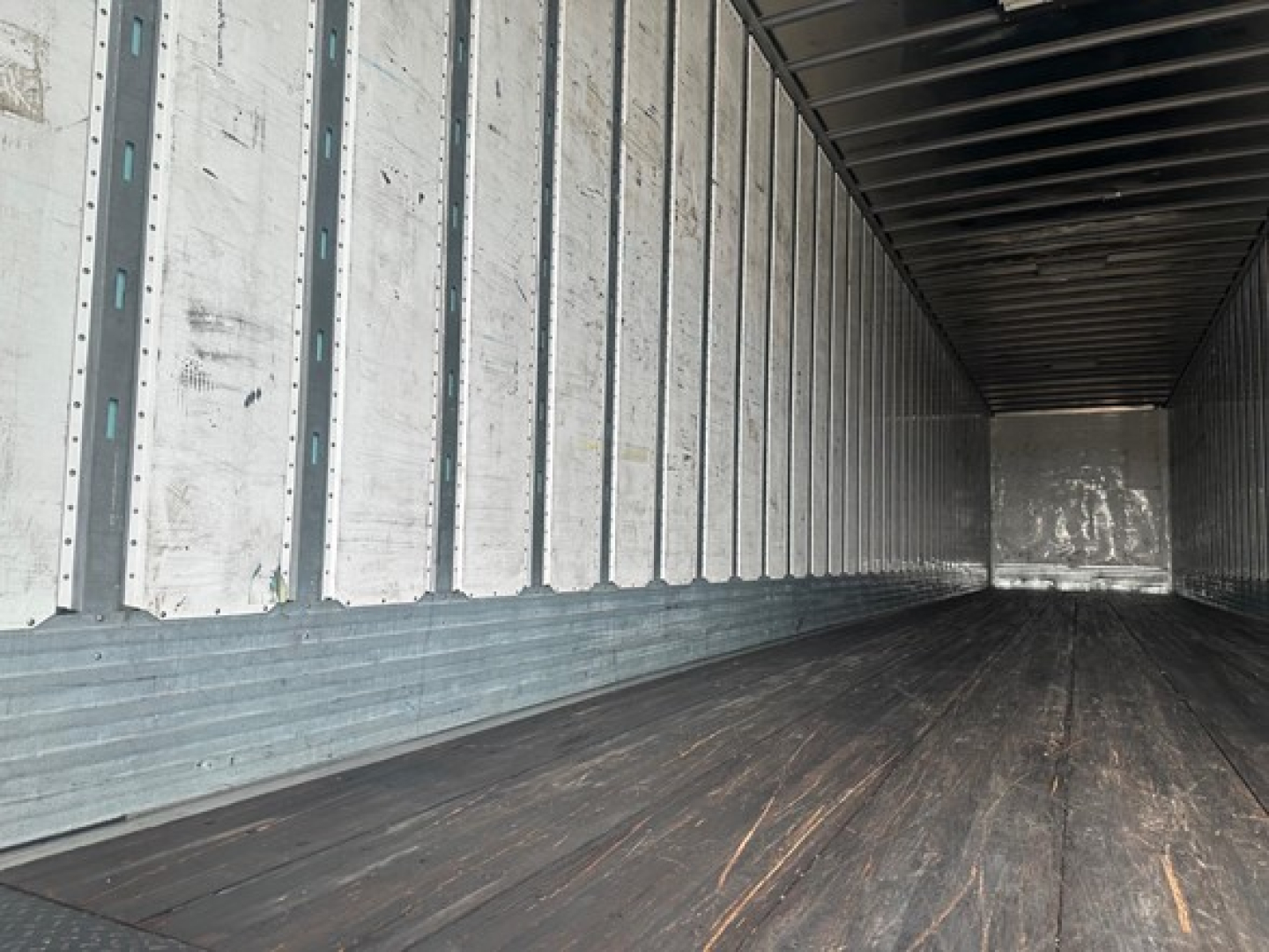 Trailer interior with metal side walls and wooden floor showing empty cargo bay of a 2018 Utility 4000Dx trailer.