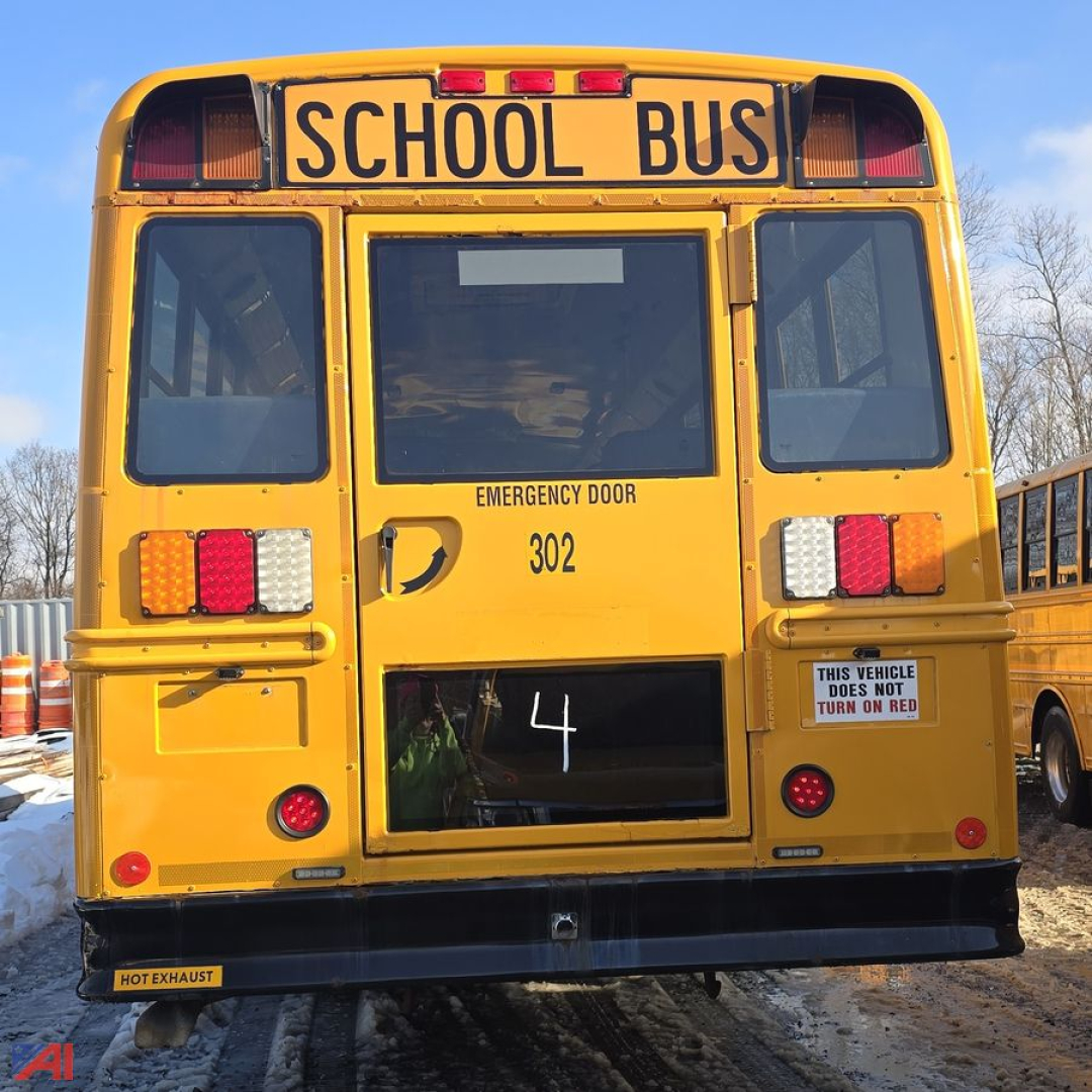 Rear view of a yellow 2014 Freightliner B2 school bus with 'SCHOOL BUS' sign, rear door, emergency door label, and bus number 302.