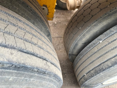 Trailer wheel close-up showing dual tires with tread lines, part of a heavy-duty dump trailer undercarriage.