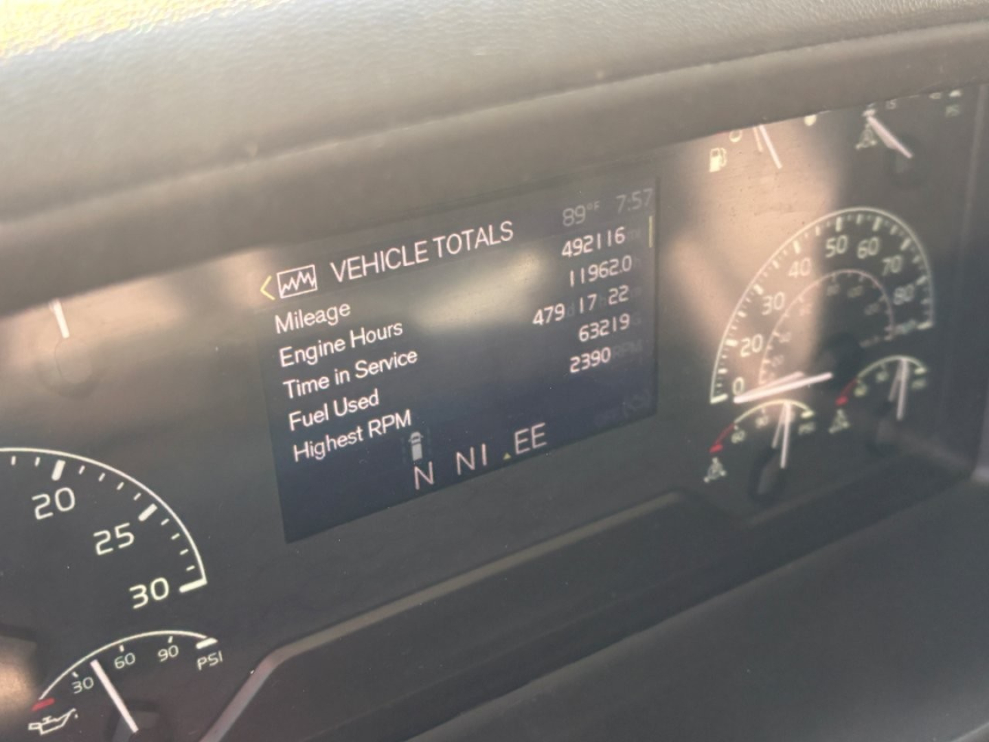 Volvo VNL dash showing Vehicle Totals with mileage, engine hours, time in service, fuel used, highest RPM; gauge cluster visible.