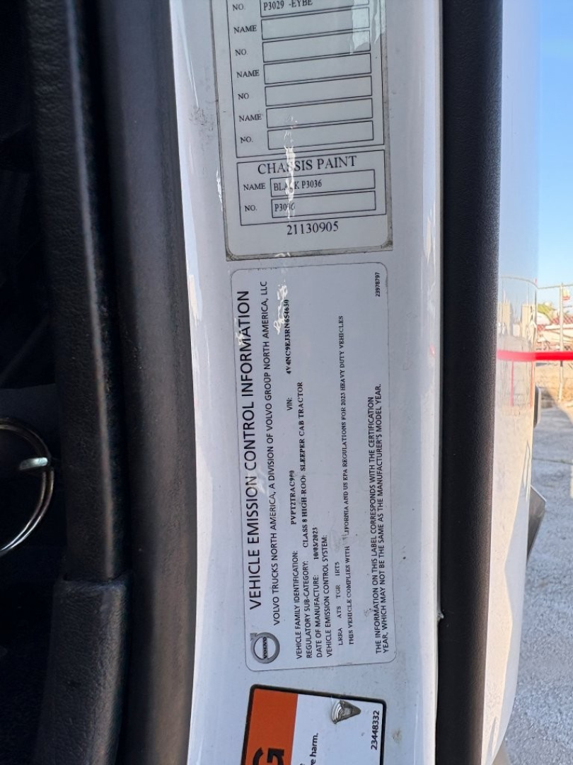 Truck door jamb label showing vehicle information and chassis paint details on a Volvo VNL124 wheel housing area.