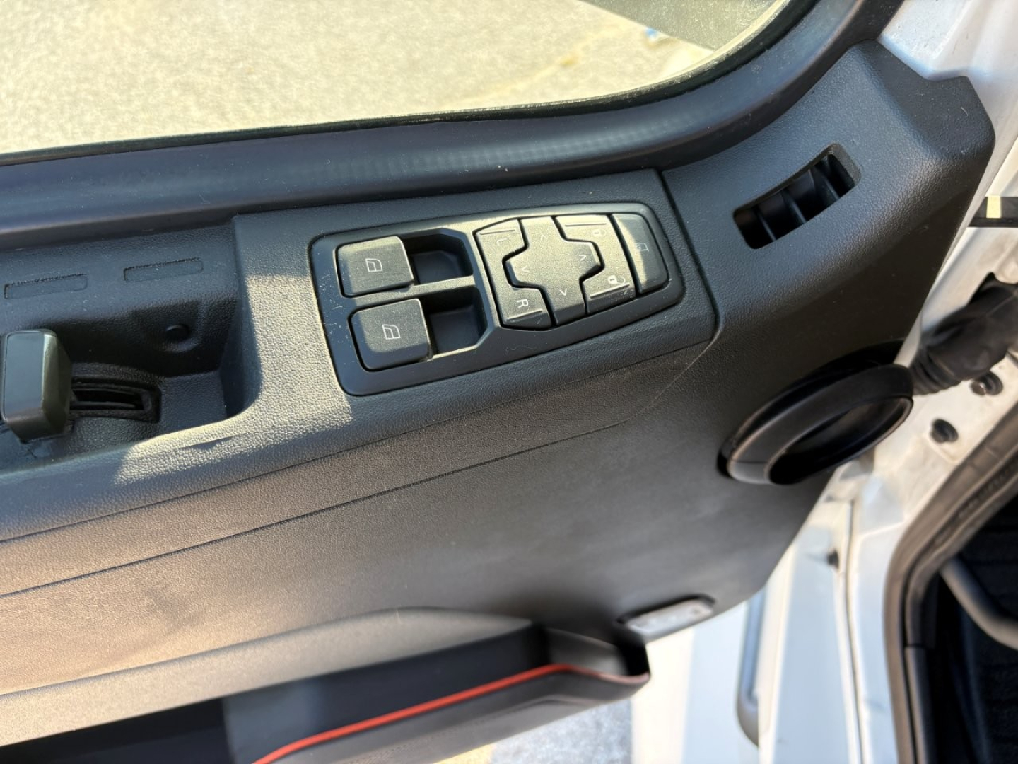 Volvo VNL64T860 truck interior door panel with window/lock controls and mirror adjustment switches in view.