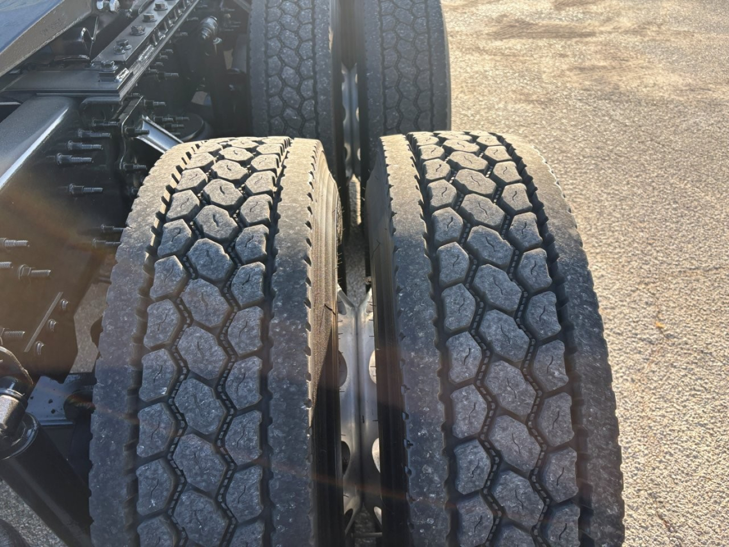 Dual rear truck tires with hexagonal tread pattern, part of a Volvo truck chassis.
