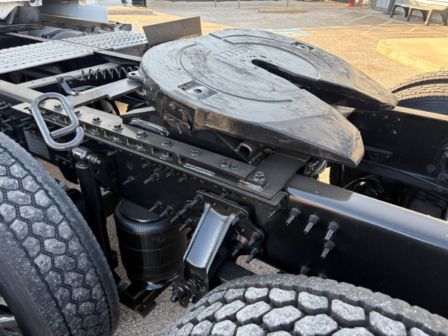 Volvo VNL64T860 drivetrain area showing fifth wheel mount and surrounding components, including air tanks, hoses, and chassis framing.