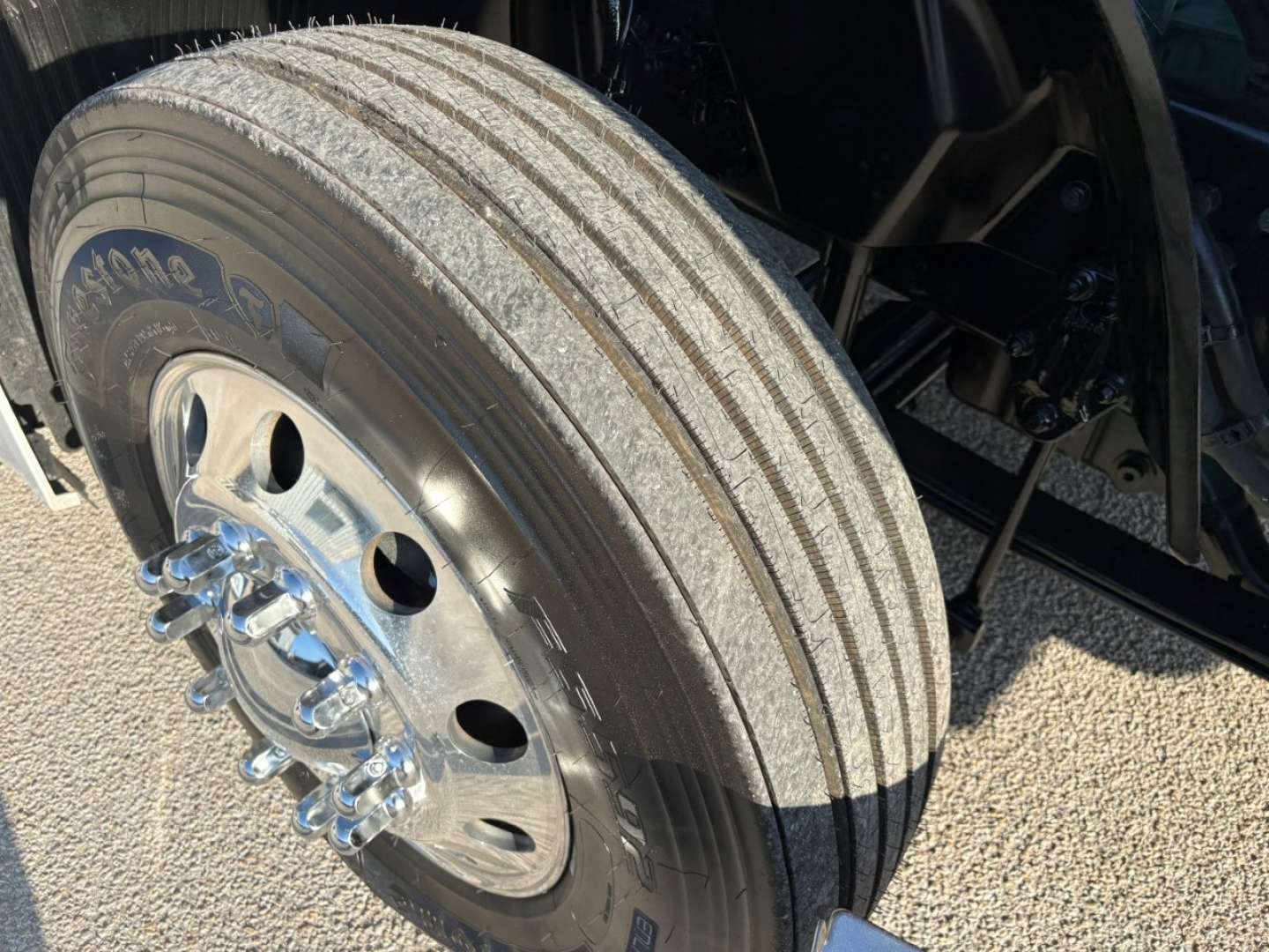 Volvo VNL64T860 truck front wheel and tire showing hub with lug nuts and wheel rim.
