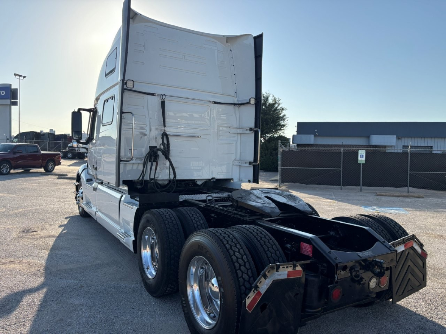 Volvo VNL64T860 tractor rear view showing twin rear axles and fifth wheel area with white sleeper cab and chrome wheels.